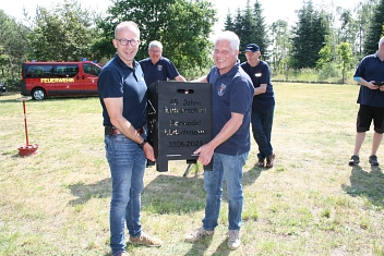 Gastgeschenk aus Lüdenhausen: Ein extra angefertigten Feuerkorb. Links im Bild Ortsbrandmeister Kai Plankemann, recht Löschgruppenführer Jörg Mendel