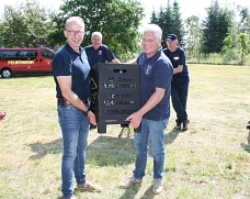 Gastgeschenk aus Lüdenhausen: Ein extra angefertigten Feuerkorb. Links im Bild Ortsbrandmeister Kai Plankemann, recht Löschgruppenführer Jörg Mendel
