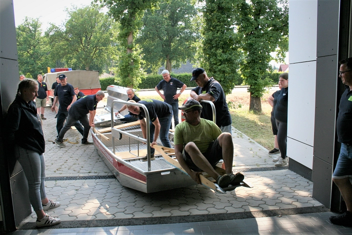 Bokensdorfs Ortsbrandmeister Mathias Deierling (vorn) erklärt ausführlich die Handhabung des Rettungsbootes