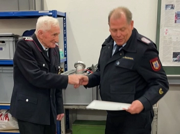 Der Kreisbrandmeister schüttelt dem Jubilar die Hand.