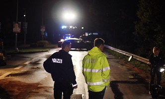 Zwei Polizisten nachts an einer Unfallstelle.