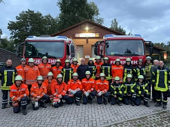 Letztes Gruppenbild mit Klaus in der Reihe der Aktiven. Aufstellung vor den beiden Fahrzeugen der Jembker Feuerwehr.