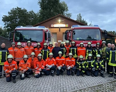 Letztes Gruppenbild mit Klaus in der Reihe der Aktiven. Aufstellung vor den beiden Fahrzeugen der Jembker Feuerwehr.